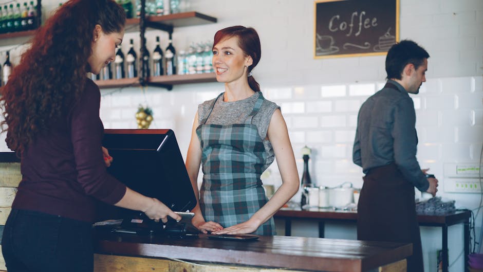 A barista interacting with a customer in a stylish, modern café interior.